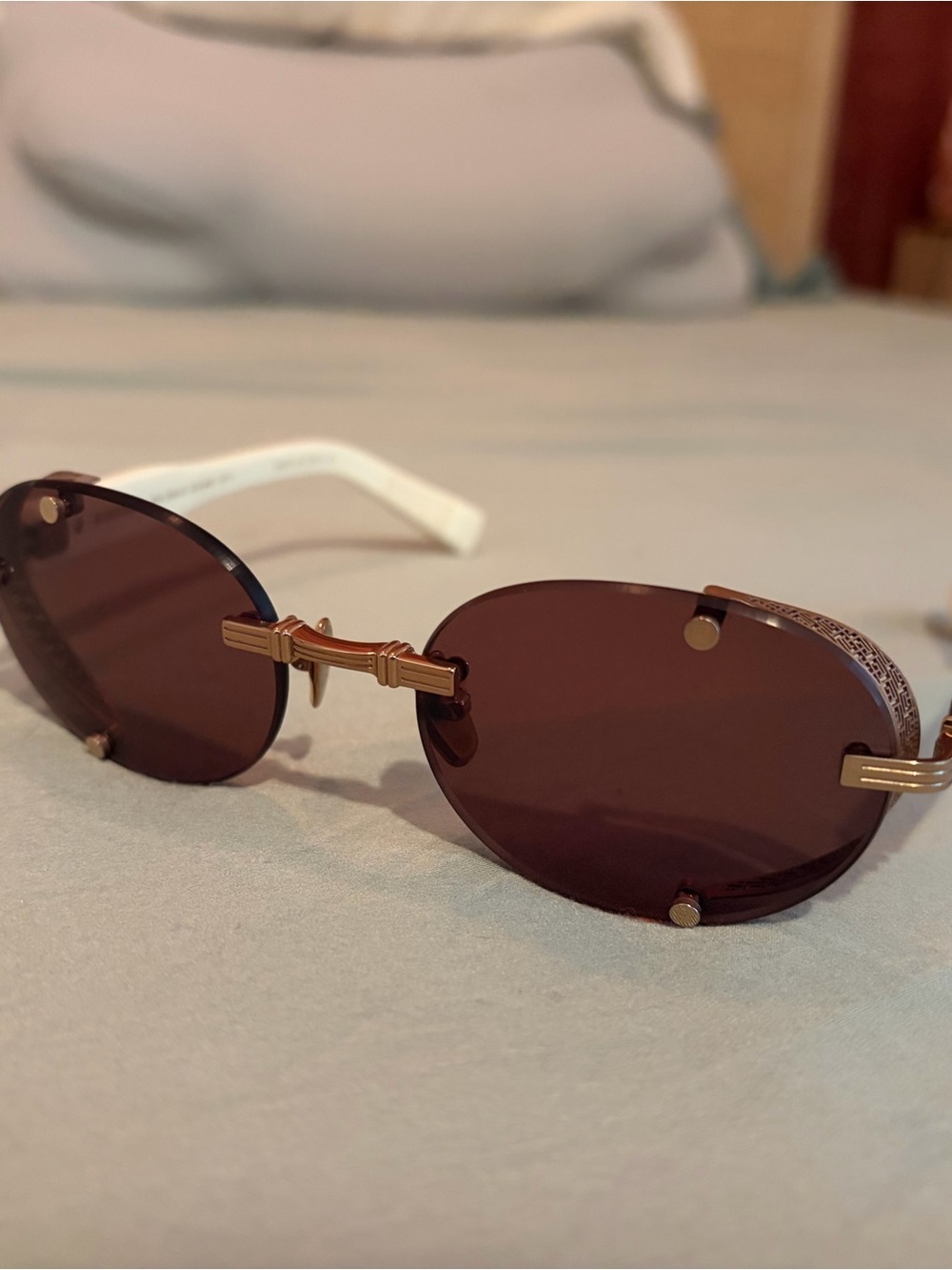 Balmain Rimless Oval Sunglasses in Brown with Gold Accents and White Temples